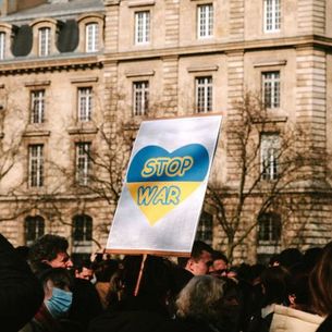 Demo-Plakat "Stop War" auf ukrainischer Flagge
