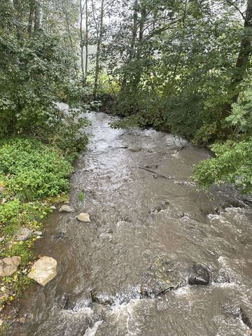Der Bach "Bracht" wird von einer Brücke aus fotografiert. Zu sehen ist sein Wasserverlauf und dass er Wasser führt.