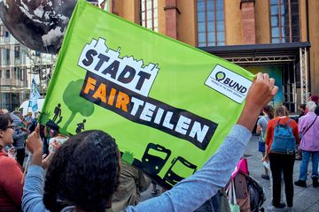 Aktivistin hält Fahne „Stadt fairteilen“ hoch (Foto: Niko Martin)