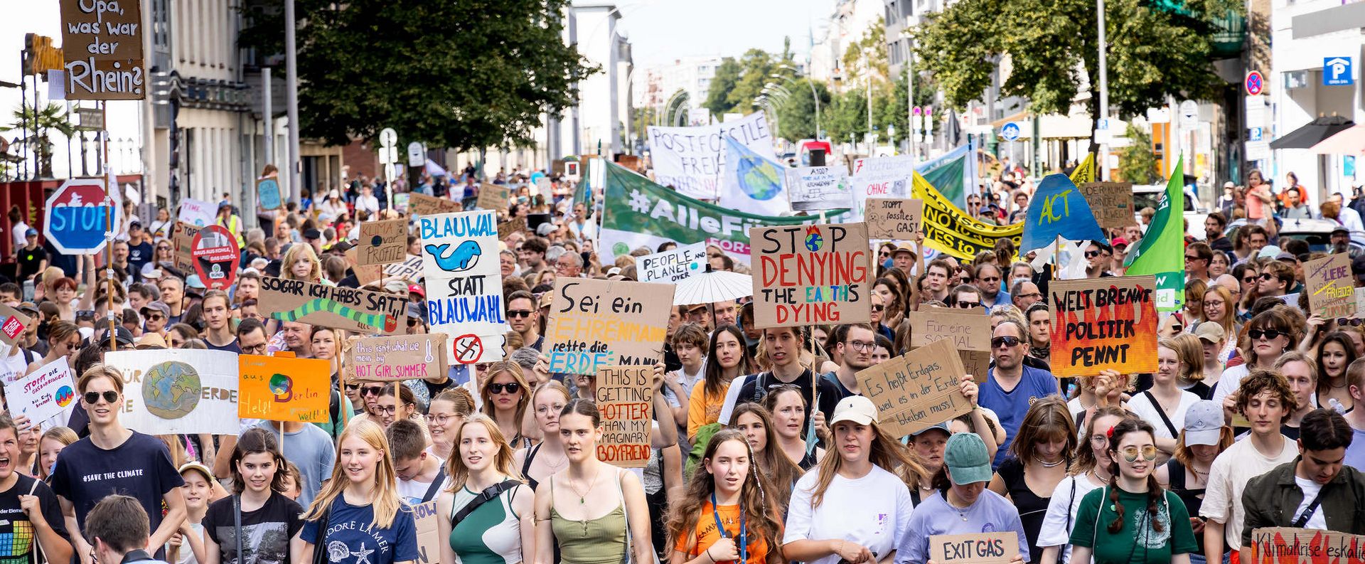 Menschen laufen in einem Demozug und halten Schilder hoch