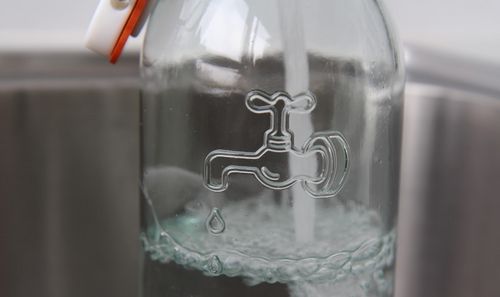 Glaskaraffe wird mit Trinkwasser befüllt.