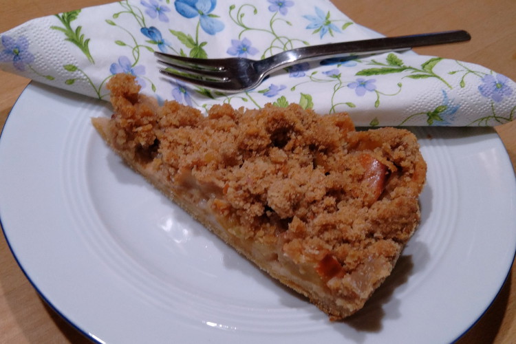 Veganer Apfelkuchen mit Streusel auf einem weißen Teller